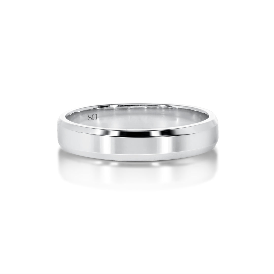 White gold polished finish wedding band with bevelled edges R12-067-W0229. This stylish finer width 18k white gold wedding band has a high polished finish applied to the centre. Faceted beveled edges have been used to catch the light and glitter in a subtle way which adds more charm to an already attractive ring. A modern and captivating look.